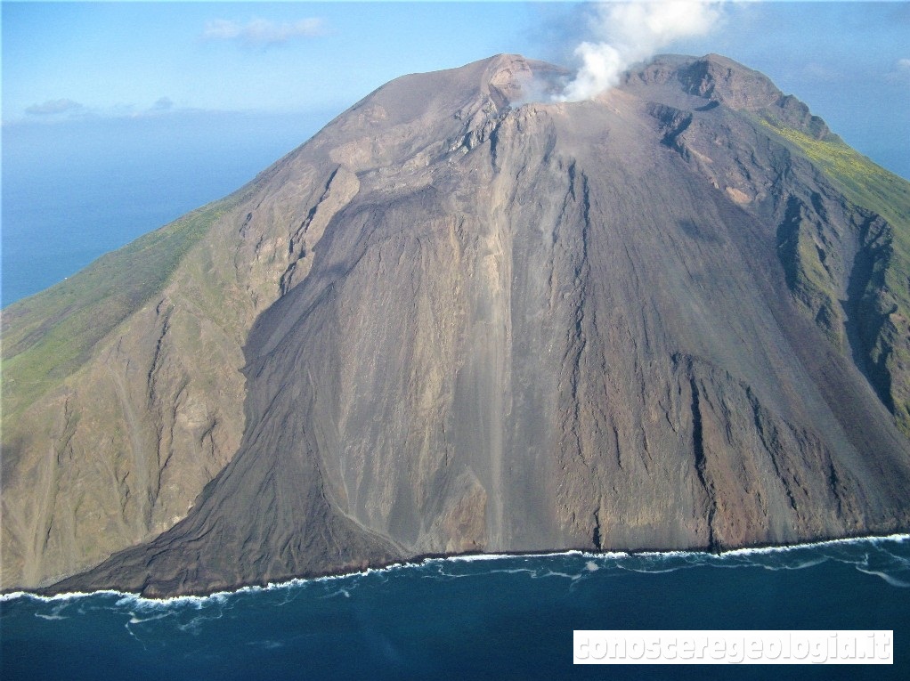 Figura 2 - La foto mostra il fianco settentrionale dello Stromboli, con i crateri che degassano nella parte alta del vulcano (dove si vede la nube bianca di gas). Alla sinistra della foto si nota il campo lavico che si è formato durante l'eruzione del 2007 lungo il fianco orientale della Sciara del Fuoco. (Foto di Sonia Calvari)